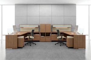 Studio shot of two L-shaped desks, with full sized windows on each side. A Graphic posture back chair is placed at each workstation.Open office design.